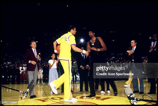 Kareem Abdul Jabbar shakes hands with Wilt Chamberlain before a ball game at the Los Angeles Forum in Los Angeles, CA. Chick Hearn the longtime Laker...