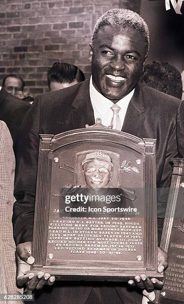 Jackie Robinson of the Brooklyn Dodgers posing with his HOF plaque during his Induction into the Baseball Hall of Fame in Cooperstown, New York.