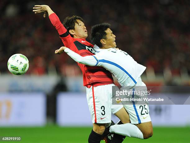 Tomoya Ugajin of Urawa Red Diamonds and Yasushi Endo of Kashima Antlers compete for the ball during the J.League Championship Final second leg match...