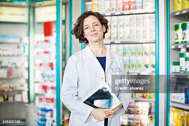 apotheker mit digitaltablett in ein chemiker store - female pharmacist with a digital tablet stock-fotos und bilder