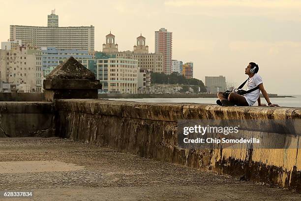 Man listens to music while sitting on the seawall along the famous Malecon as daily life resumes in the capital city following a nine-day mouring...