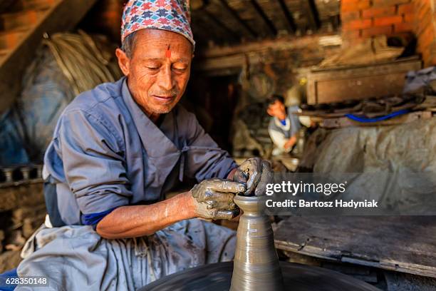 nepali potter working on the pottery square in bhaktapur - nepal culture stock pictures, royalty-free photos & images