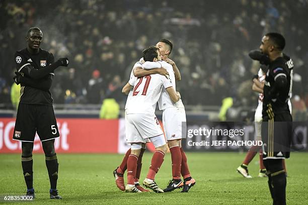 Sevilla's players celebrate as Lyon's French forward Alexandre Lacazette and Lyon's defender Mouctar Diakhaby react at the end of the UEFA Champions...