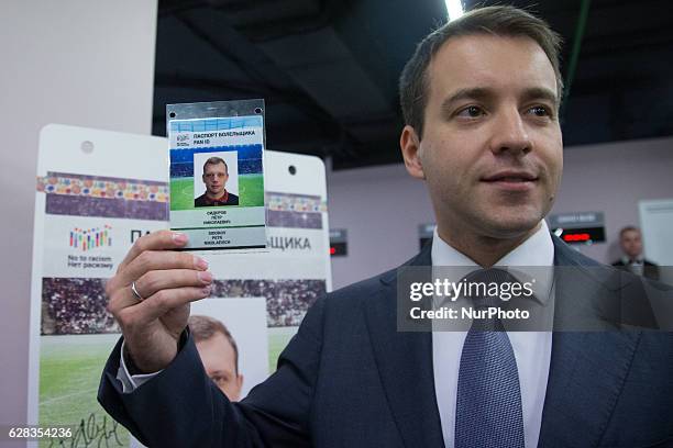 Russia's Communications and Mass Media Minister Nikolai Nikiforov shows a fan-ID card at the opening ceremony of the first centre for registration...