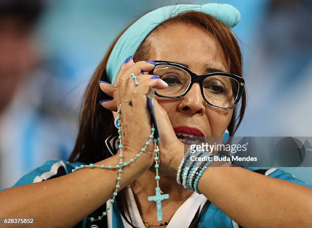 Fan of Gremio prays before during a match between Gremio and Atletico MG as part of Copa do Brasil Final 2016 at Arena do Gremio on December 07, 2016...