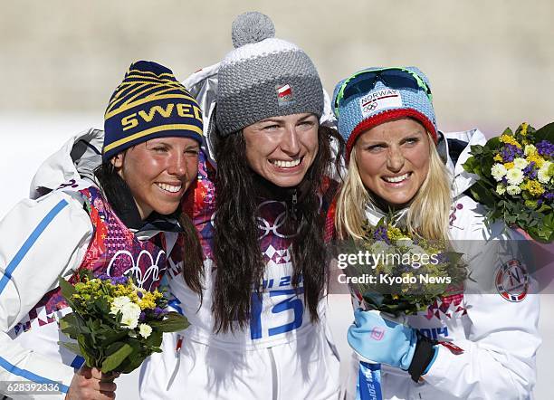 Russia - Gold medalist Justyna Kowalczyk of Poland celebrates with Sweden's Charlotte Kalla , silver medalist, and Norway's Therese Johaug, bronze...