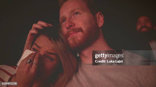 mujeres llorando mientras ven una película en una sala de cine - hombre llorando fotografías e imágenes de stock