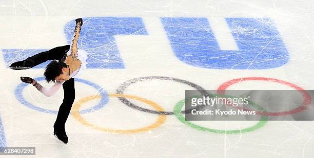 Russia - Japan's Yuzuru Hanyu performs a spin near the Olympic rings logo in the ice during his free program in the men's figure skating competition...