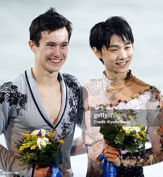 Russia - Japan's Yuzuru Hanyu and Canada's Patrick Chan smile during a flower ceremony for the men's figure skating competition at the Sochi Winter...