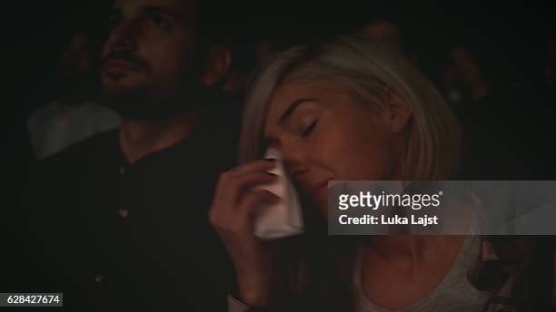women crying while watching movie in a cinema hall - teardrop stock pictures, royalty-free photos & images