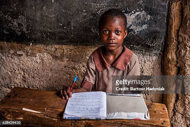 piccola bambina africana è apprendimento lingua inglese, orfanotrofio in kenya - casa famiglia foto e immagini stock