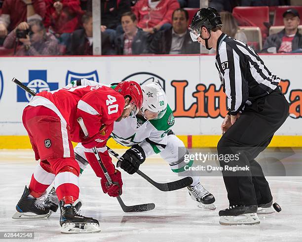 Linesman Devin Berg drops the puck between Henrik Zetterberg of the Detroit Red Wings and Cody Eakin of the Dallas Stars during an NHL game at Joe...