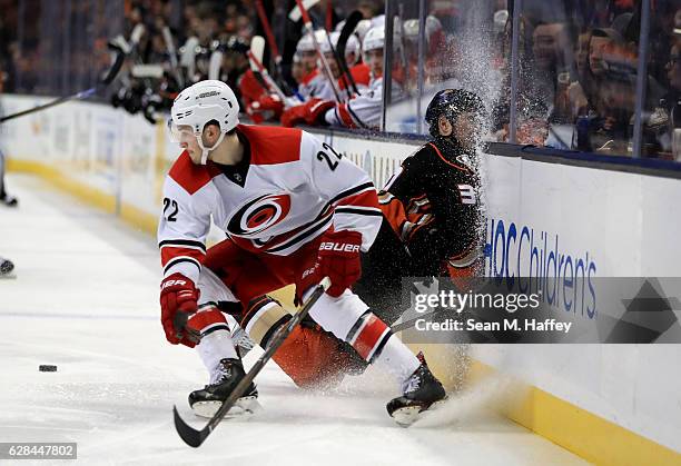 Brett Pesce of the Carolina Hurricanes checks Nick Ritchie of the Anaheim Ducks into the boards during the third period of a game at Honda Center on...