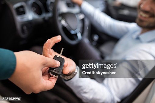 Nahaufnahme eines Mannes, der einen neuen Autoschlüssel erhält. Nahaufnahme eines Mannes, der einen neuen Autoschlüssel erhält.