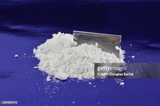 illegal drug in power form and a razor blade - riga foto e immagini stock