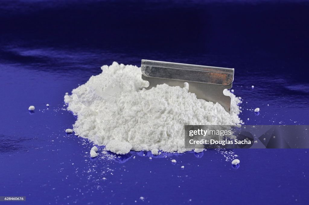 Illegal Drug in power form and a razor blade