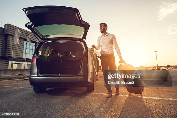 young smiling businessman going on a business trip. - company car stock pictures, royalty-free photos & images