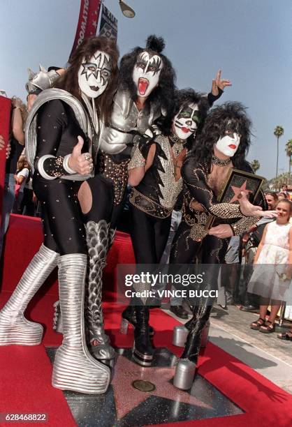 Members of the rock band Kiss : Ace Frehley, Gene Simmons, Peter Criss and Paul Stanley stand on the star they received during a Hollywood Walk of...