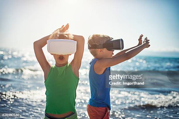 kleine jungs am virtual-reality-strand - familie technologie virtuell stock-fotos und bilder