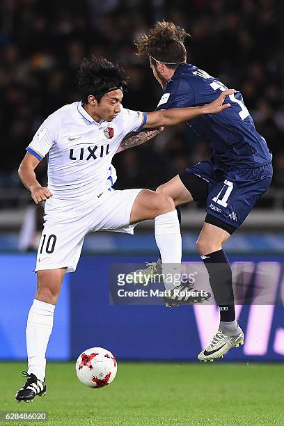 Gaku Shibasaki of Kashima Antlers competes for the ball against Fabrizio Tavano of Auckland City during the FIFA Club World Cup Play-off for Quarter...