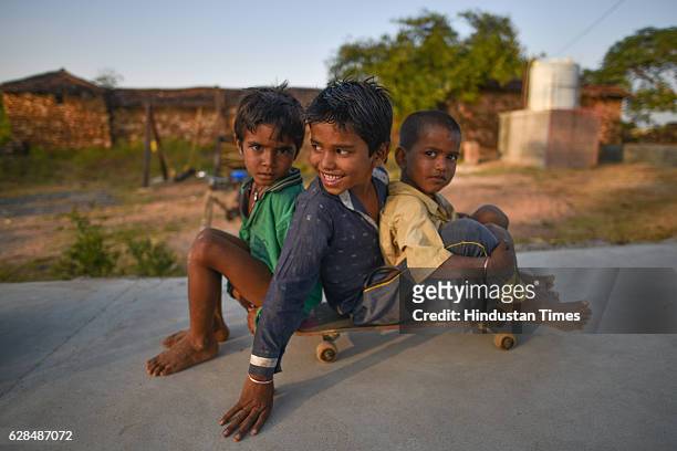 Three young boys riding on a single skate board at Skating park, popularly known as Janwaar Castle on October 26, 2016 in Janwaar, India. Thanks to a...