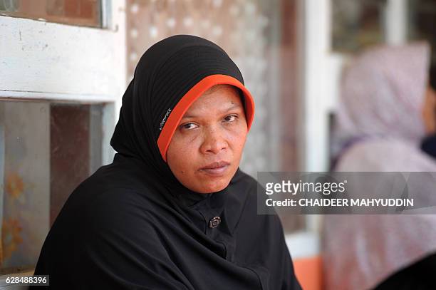 Rahmawati, whose husband and two children were killed after the earthquake struck, sits in a shelter in Kuta Pangwa village in Pidie Jaya on December...