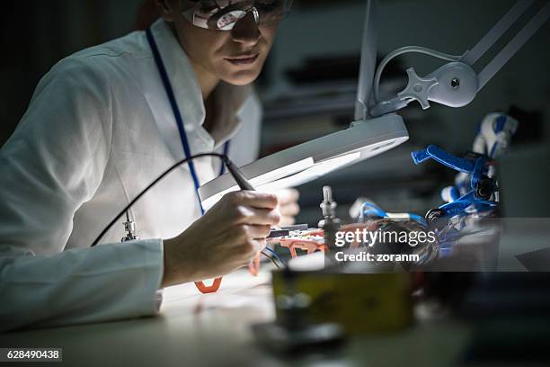 female electrician working on drone - lupa equipamento ótico imagens e fotografias de stock