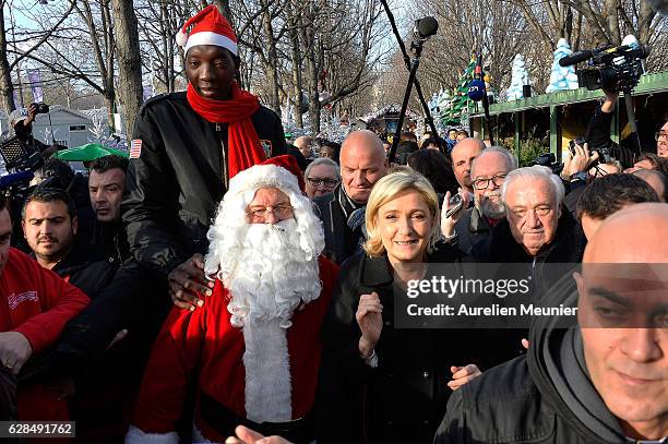 Marine Le Pen, President of the French far right political party Front National, visits the Christmas Market on the Champs Elysees on December 8,...