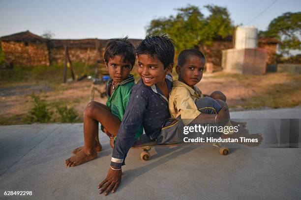 Three young boys riding on a single skateboard at Skating Park, popularly known as Janwaar Castle, on October 26, 2016 in Janwaar, India. Thanks to a...