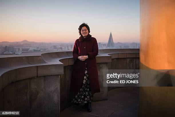 In this photo taken on November 28 tour guide Choe Hee-Ok poses for a photo atop the landmark Juche Tower where she works in Pyongyang. / AFP / Ed...