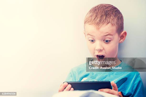 excited boy playing with a smartphone. - little passion stock pictures, royalty-free photos & images