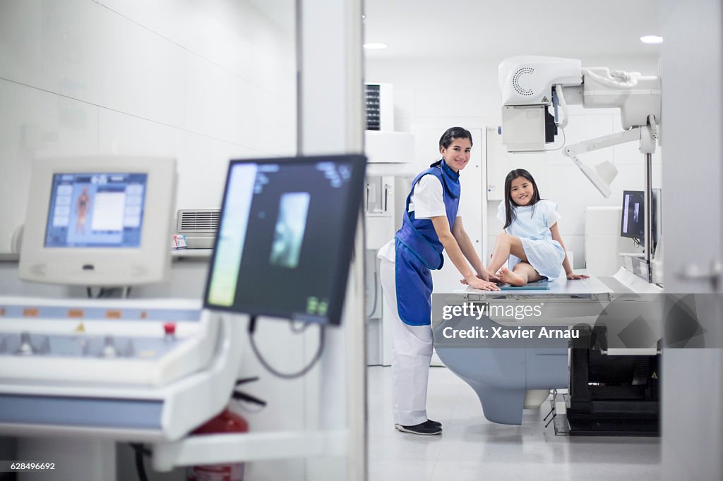 Médico que toma radiografía de pie de niña en el hospital