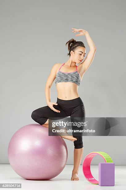 pilates stretching  training   woman practicing on a fitness ball - training wheels imagens e fotografias de stock