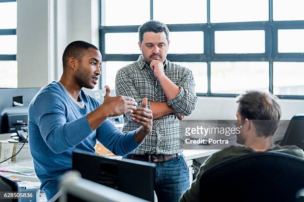 businessmen discussing in creative office - informeel zakelijk stockfoto's en -beelden