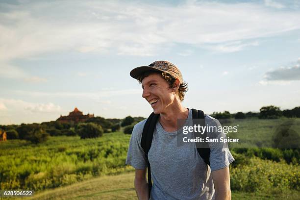 western backpacker smiling outdoors with temple in the background, south east asia. - gap year stock pictures, royalty-free photos & images