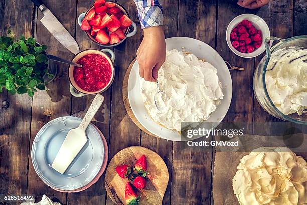 preparação de berry pavlova bolo com morangos e framboesas - merengue imagens e fotografias de stock