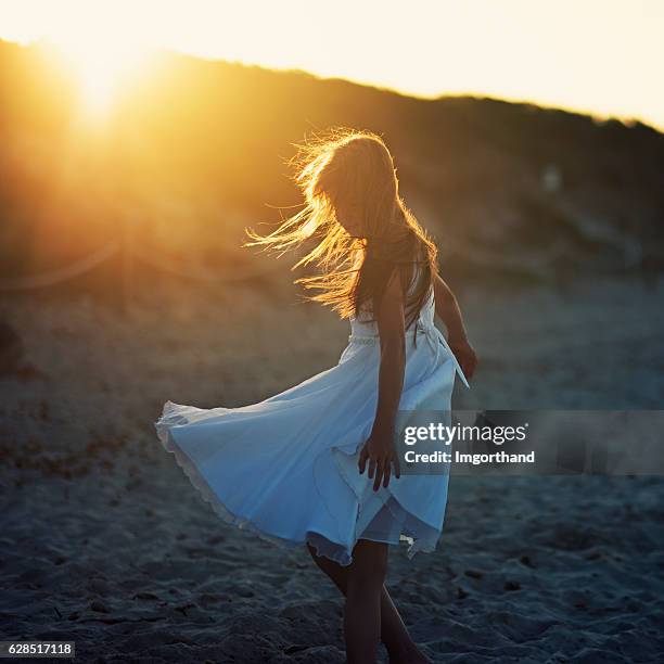 little girl dancing on the beach. - sundress stock pictures, royalty-free photos & images