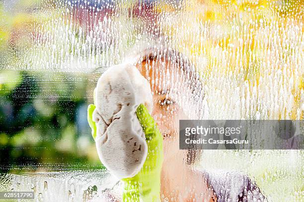 junge frau reinigung von windows - cleaning stock-fotos und bilder