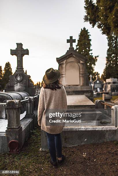 junge frau auf dem friedhof - cemetery stock-fotos und bilder