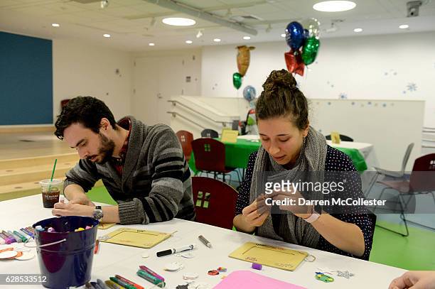Fiddler On The Roof cast members Patrick Varner and Abby Goldfarb decorate picture frames for the kids at Boston Children's Hospital on December 8,...