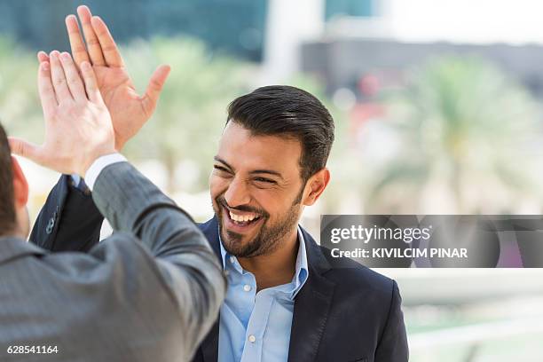 erfolgreicher arabischer geschäftsmann - high five stock-fotos und bilder