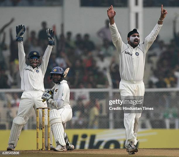 Cricket - India vs Sri Lanka Test Series - India bowler Harbhajan Singh celebrates with wickewt keeper MS Dhoni the wicket of Sri Lanka batsman...