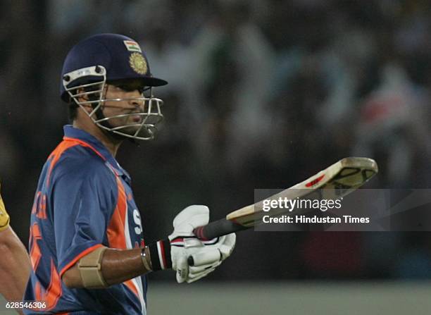 India batsman Sachin Tendulkar raises his bat after completing his 17000 runs during the 5th ODI between India and Australia at Rajiv Gandhi stadium,...