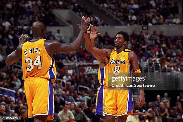 Shaquille O'Neal and Kobe Bryant of the Los Angeles Lakers high five each other during a National Basketball Association game against the Orlando...