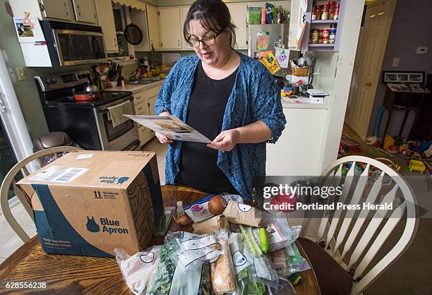 Emily Griffin reads a recipe for a Blue Apron meal while unpacking her box at her Lisbon Falls home on Tuesday, Dec. 6, 2016.