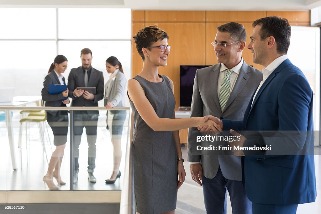 Senior business partner and young female colleague shaking hands