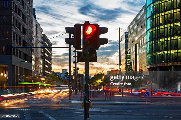 red traffic lights and vehicle lights at rush hour in berlin, potsdamer platz (germany) - red light stock-fotos und bilder