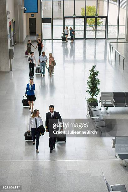 passengers and crew walking through airport - airport from above stock pictures, royalty-free photos & images