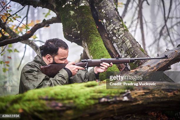 hunter shooting at target - leaf on roof stockfoto's en -beelden