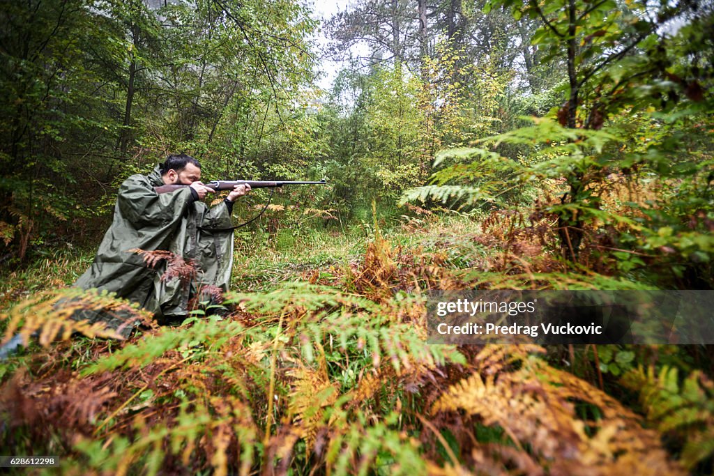 Hunter aiming with rifle